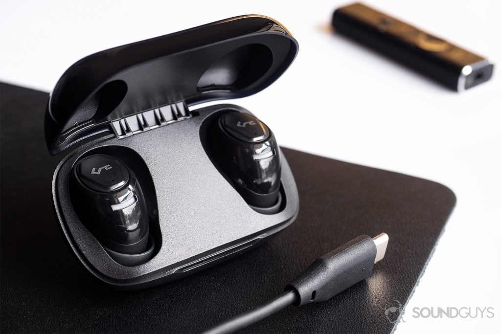 Aukey EP-T16 review: The earbuds in the case which is slightly angled on a black mouse pad. The bottom right corner shows an USB-C cable.