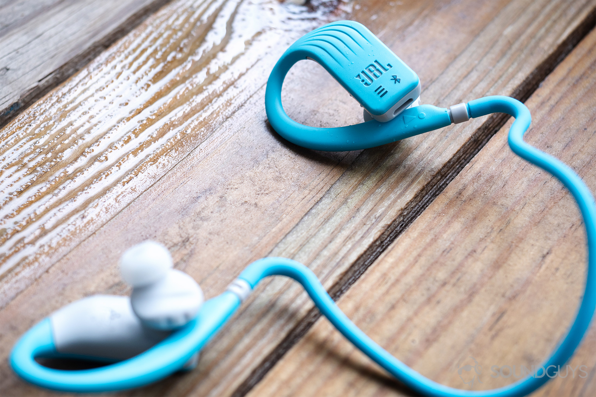 JBL Endurance Dive: The headphones on a wet wooden surface.