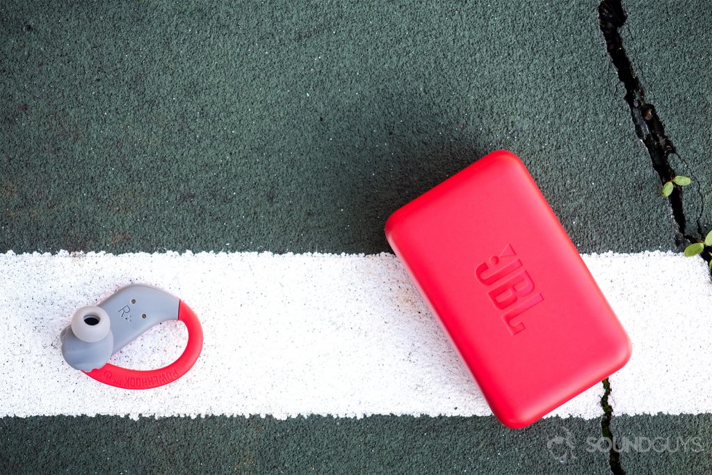 JBL Endurance Peak: Top-down image of the right earbud with the nozzle facing the lens and the case.