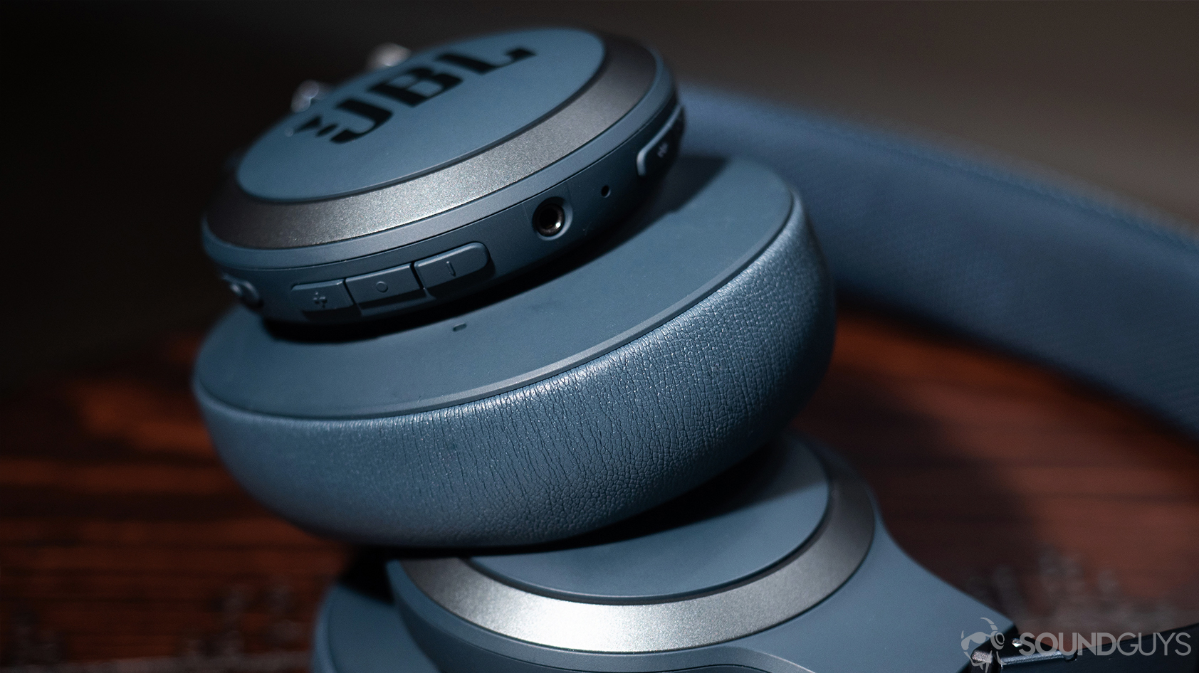 A picture of the JBL Live 650BTNC noise canceling headphones' on-board controls and 3.5mm aux input.
