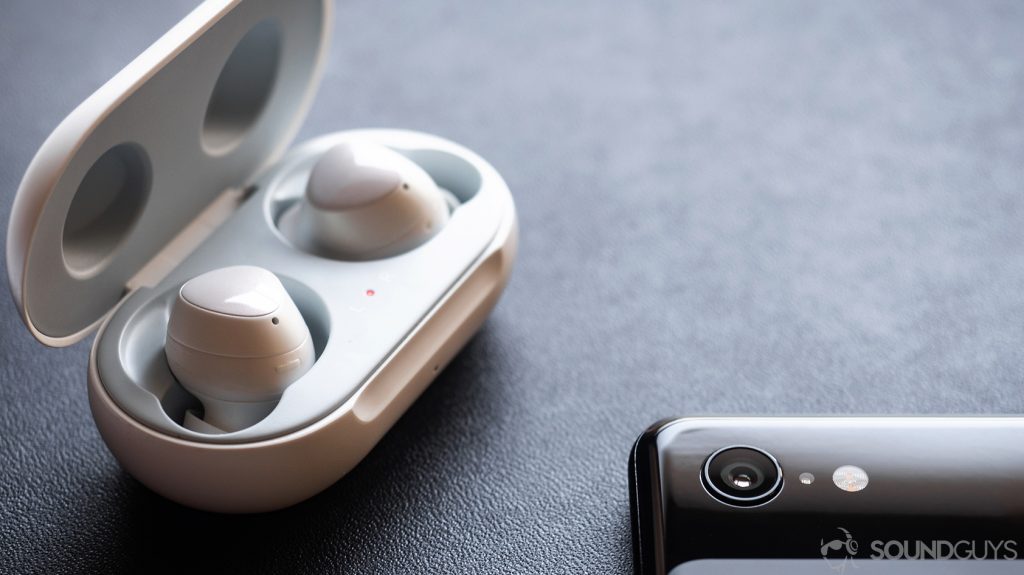 A picture of the Samsung Galaxy Buds earbuds in the case, which is open, with part of a Google Pixel 3 in the bottom left corner of the image.