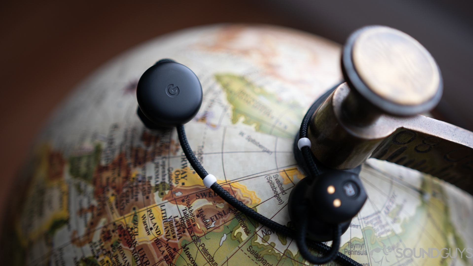 Google Pixel Buds-2 Pictured is the G" logo on the all-black Google Pixel Buds on top of a globe.