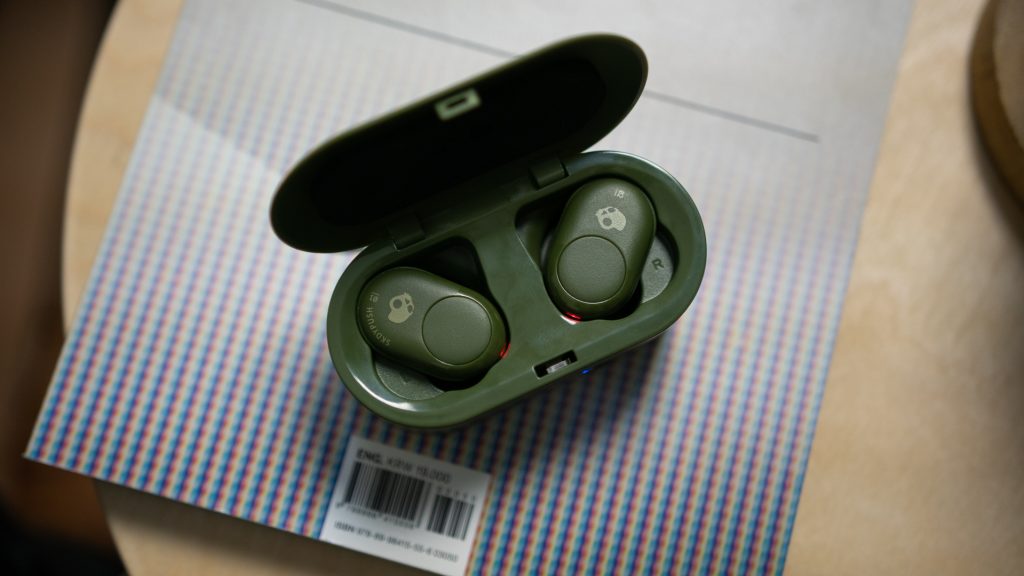 The Skullcandy Push true wireless earbuds in the charging case on top of a magazine. 