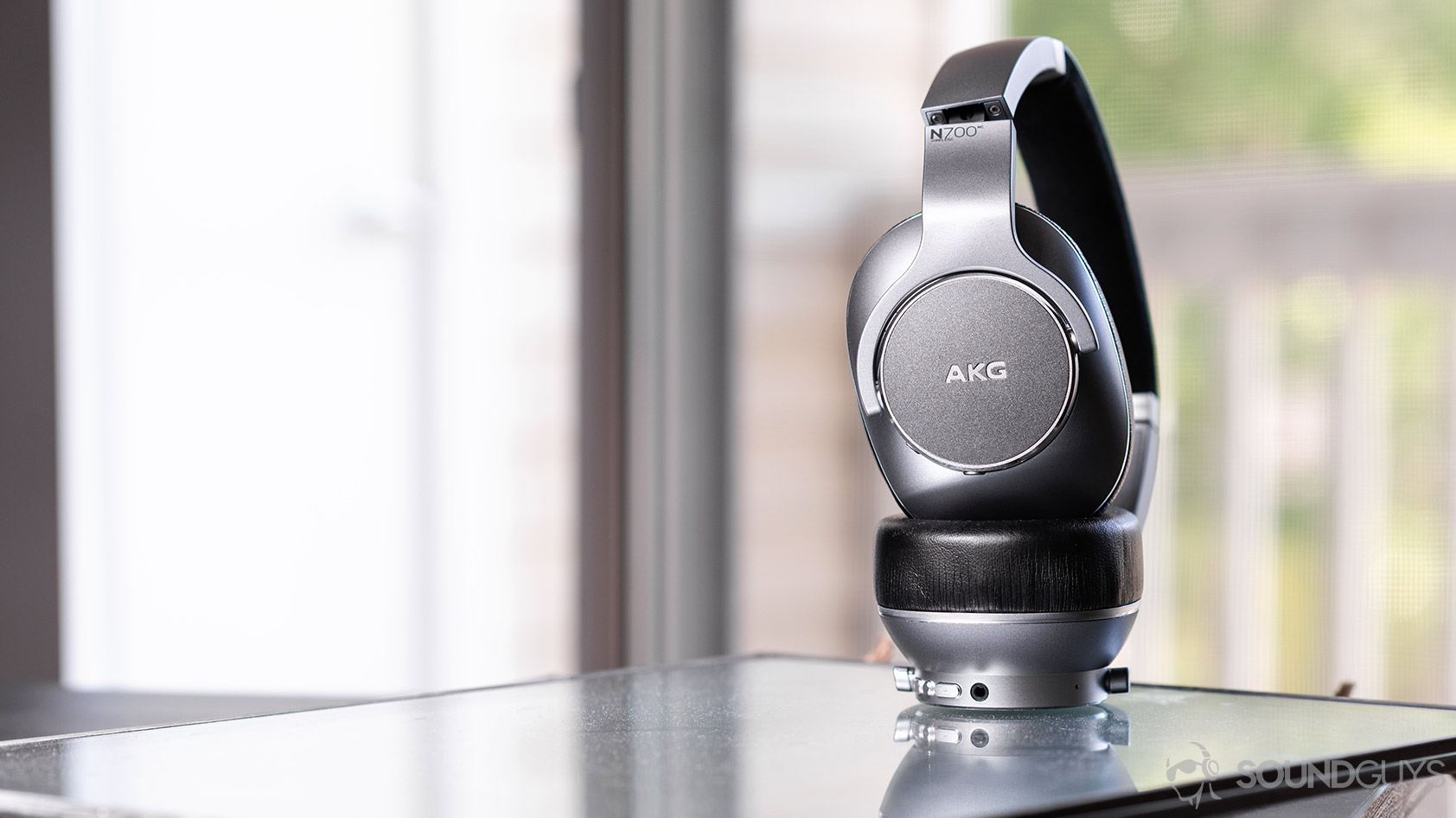 AKG_N700NC-2_headphones folded standing AKG N700NC: Headphones standing vertically against a window.