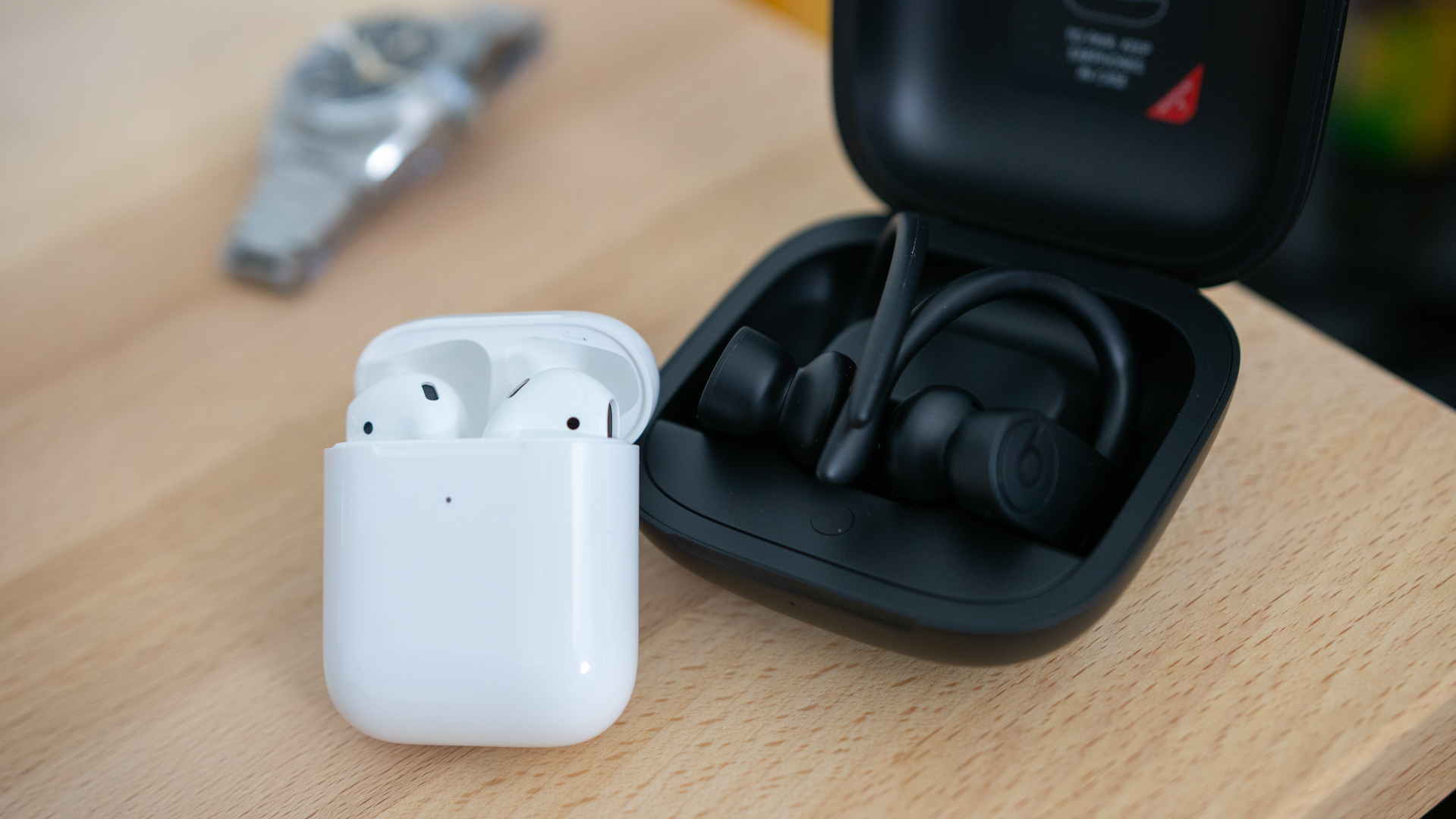 Shot of both the Apple Airpods and Powerbeats Pro in their respective charging case.