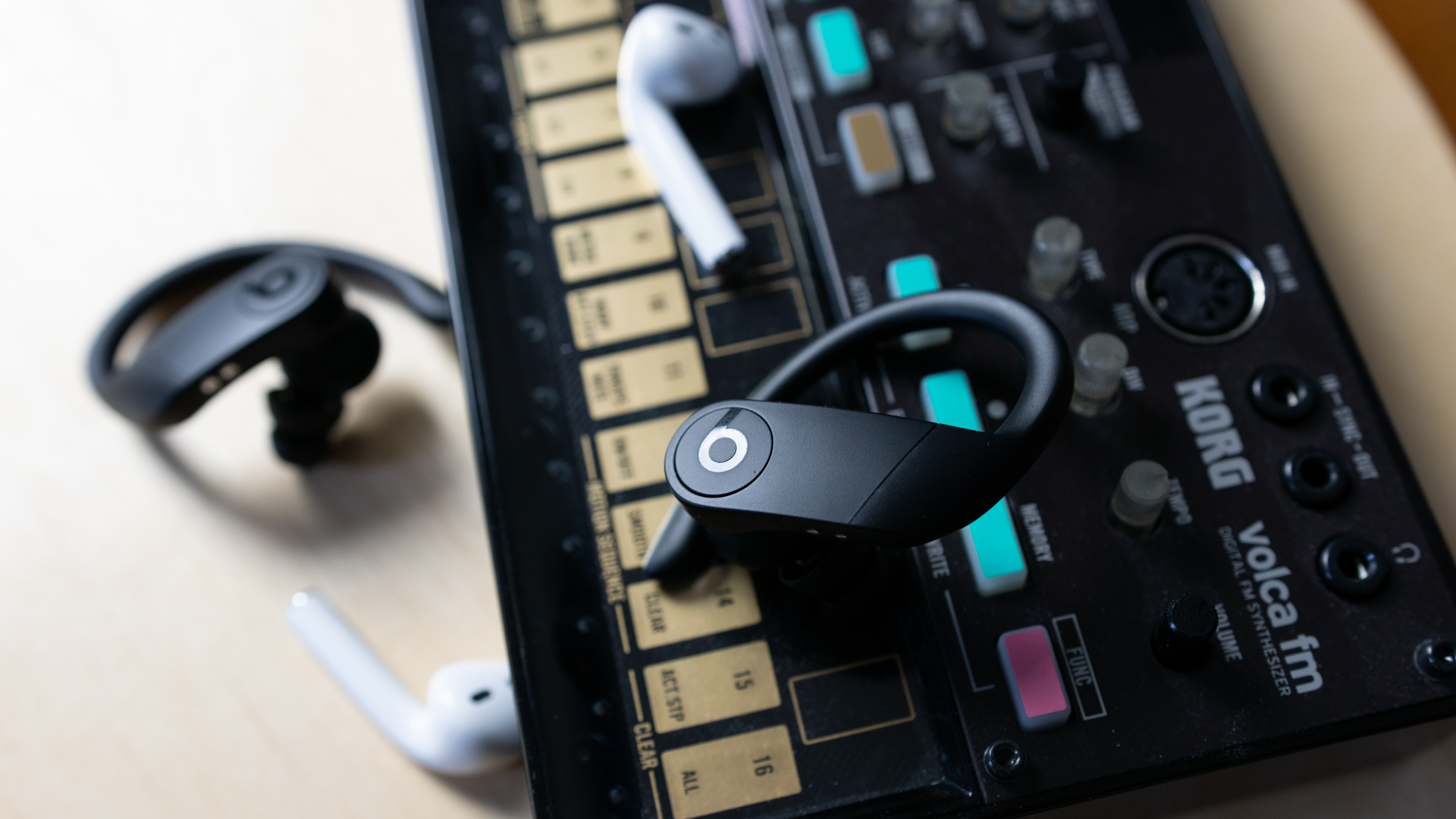 Close-up of the Apple Airpods and the Powerbeats Pro on a synth.