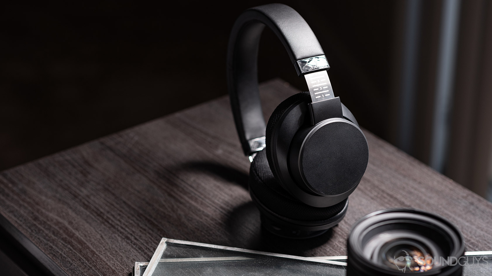 Creative_SXFI Air-3_headphones lens wood desk Creative SXFI Air: Headphones standing and angled, completely in frame.