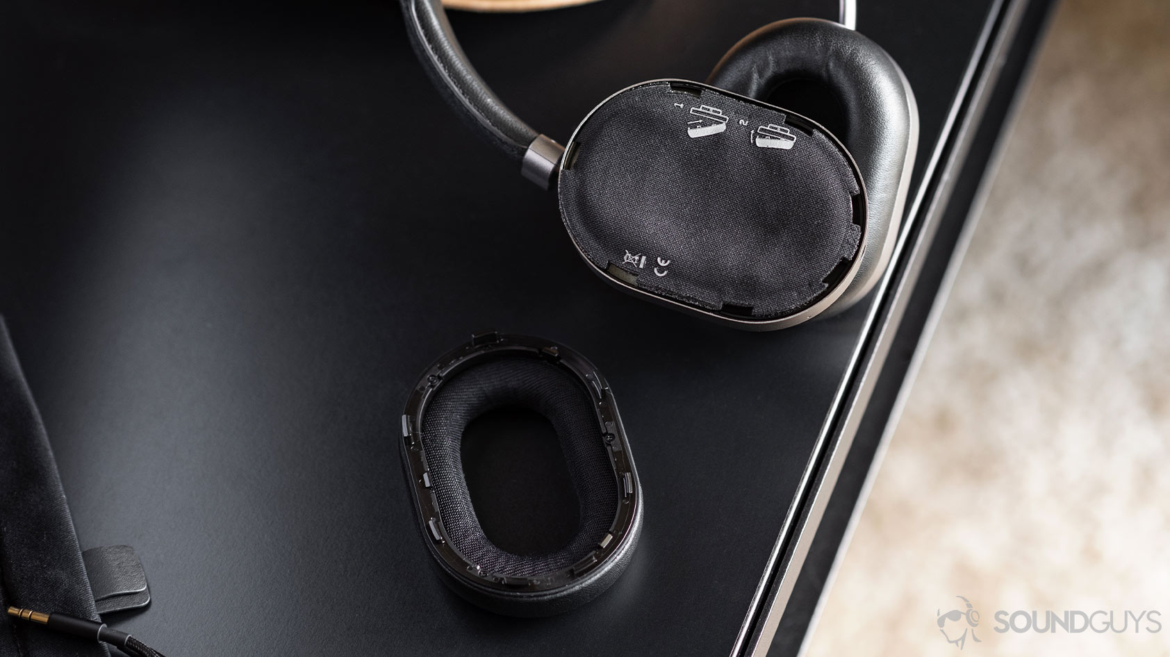 Master &amp; Dynamic MW65: Removable ear cup on a table, showing bare headphone.