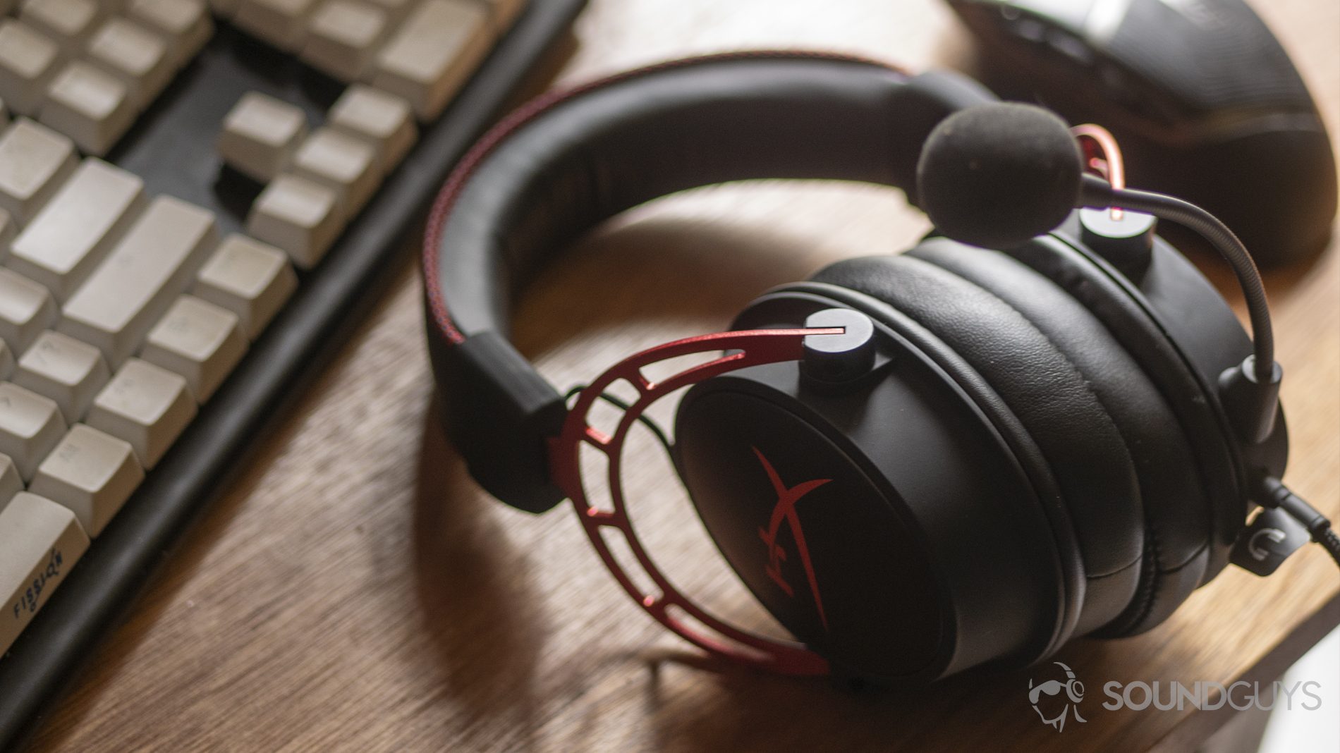 A photo of the HyperX Cloud Alpha on a desk, flanked by a gaming mouse and mechanical keyboard.