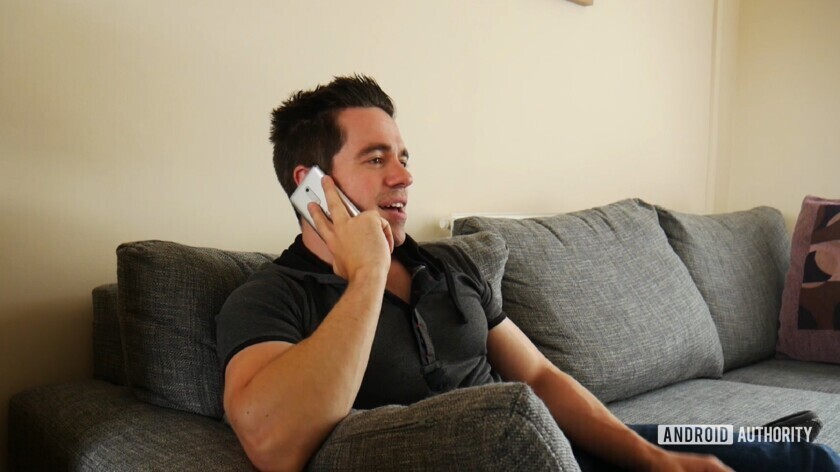 A man using a smartphone to make a phone call using his voice.