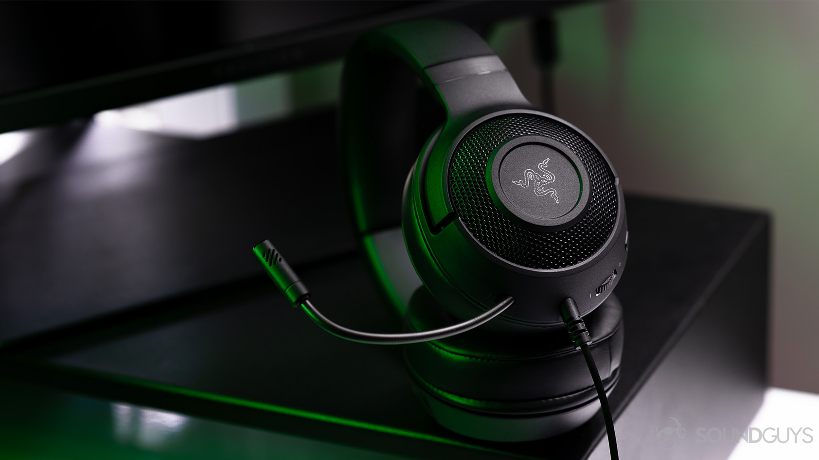 The Razer Kraken X headphones angled on a computer stand with the microphone bent slightly upward.