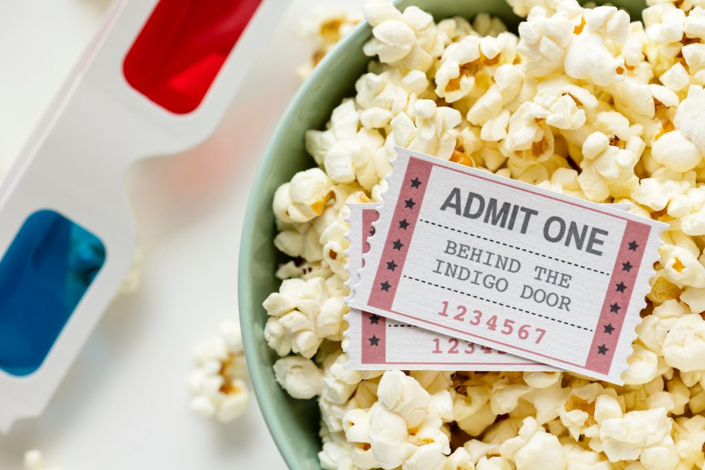 popcorn bowl with movie tickets and 3D glasses off to the side.