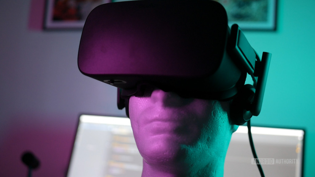A VR headset on a dummy head with purple and teal LED lighting.