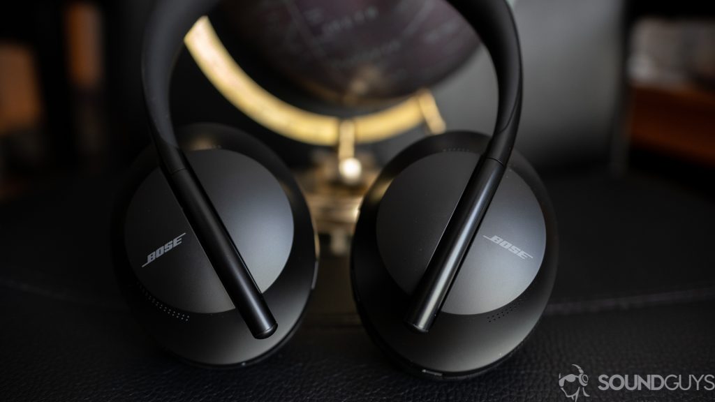 The Bose Noise Cancelling Headphones 700 on black surface with globe in the background. 