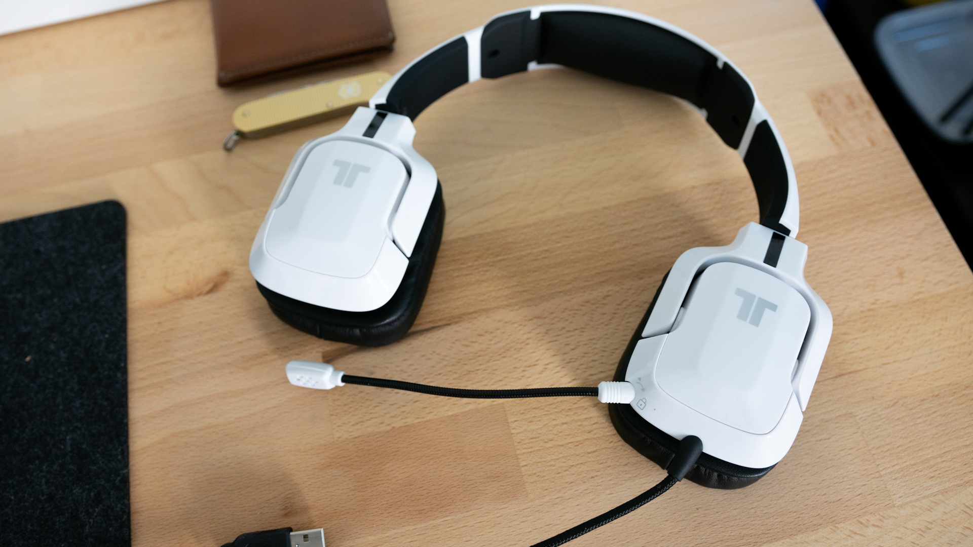 Pictured are the Tritton Kunai Pro headphones on desk.