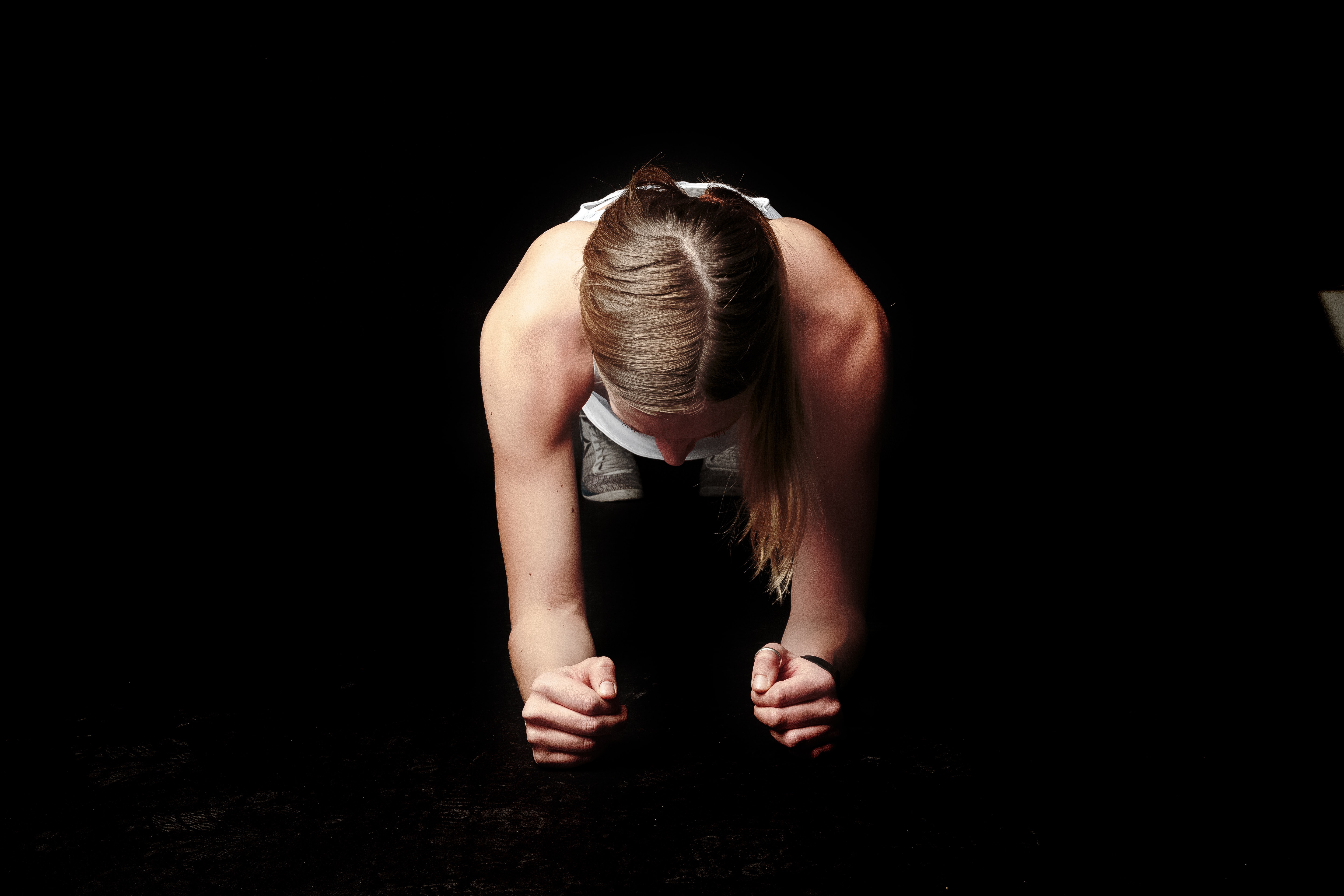 Photo of Woman Doing Plank against Black Background