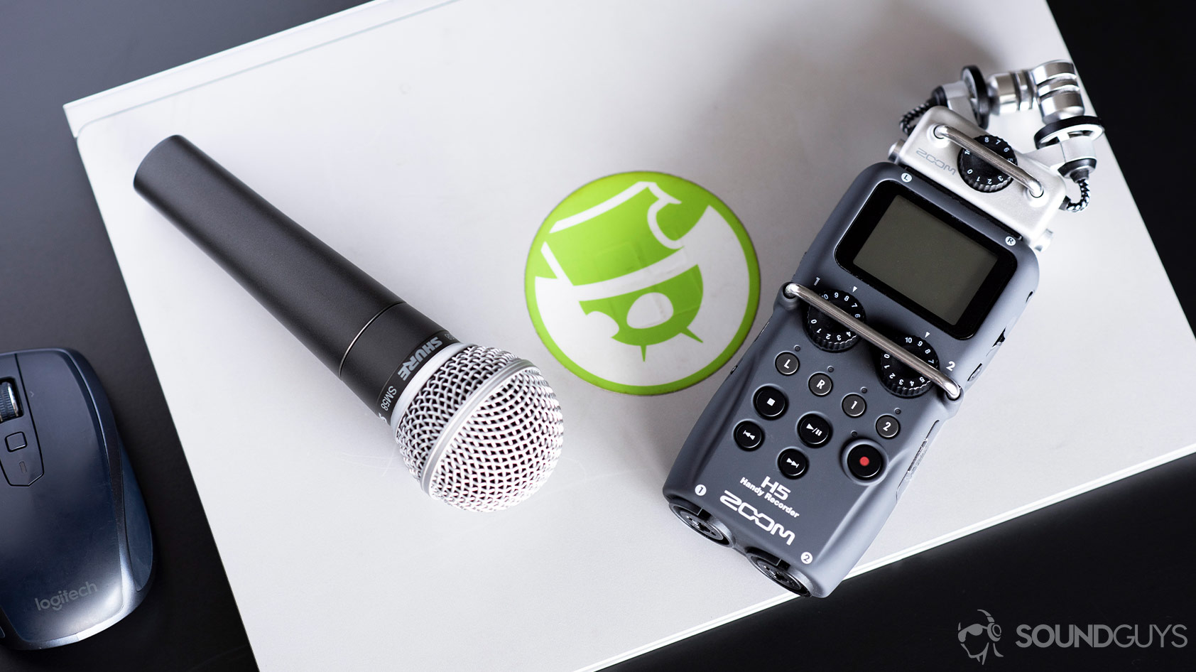 Shure SM58 microphone next to a Zoom H5 handheld voice recorder for field recording.