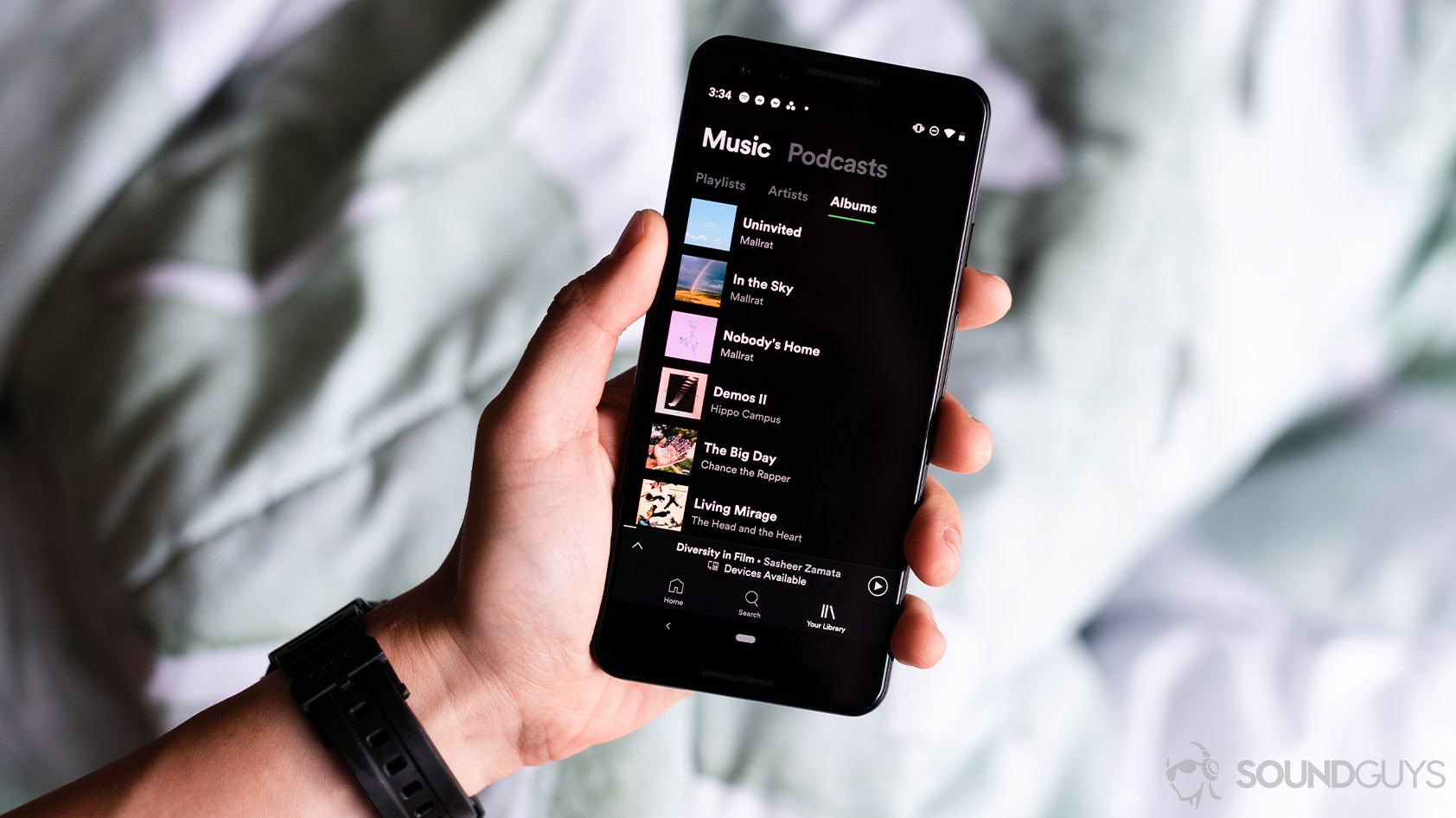 A picture of the Google Pixel 3 held by a hand with the Spotify app open.