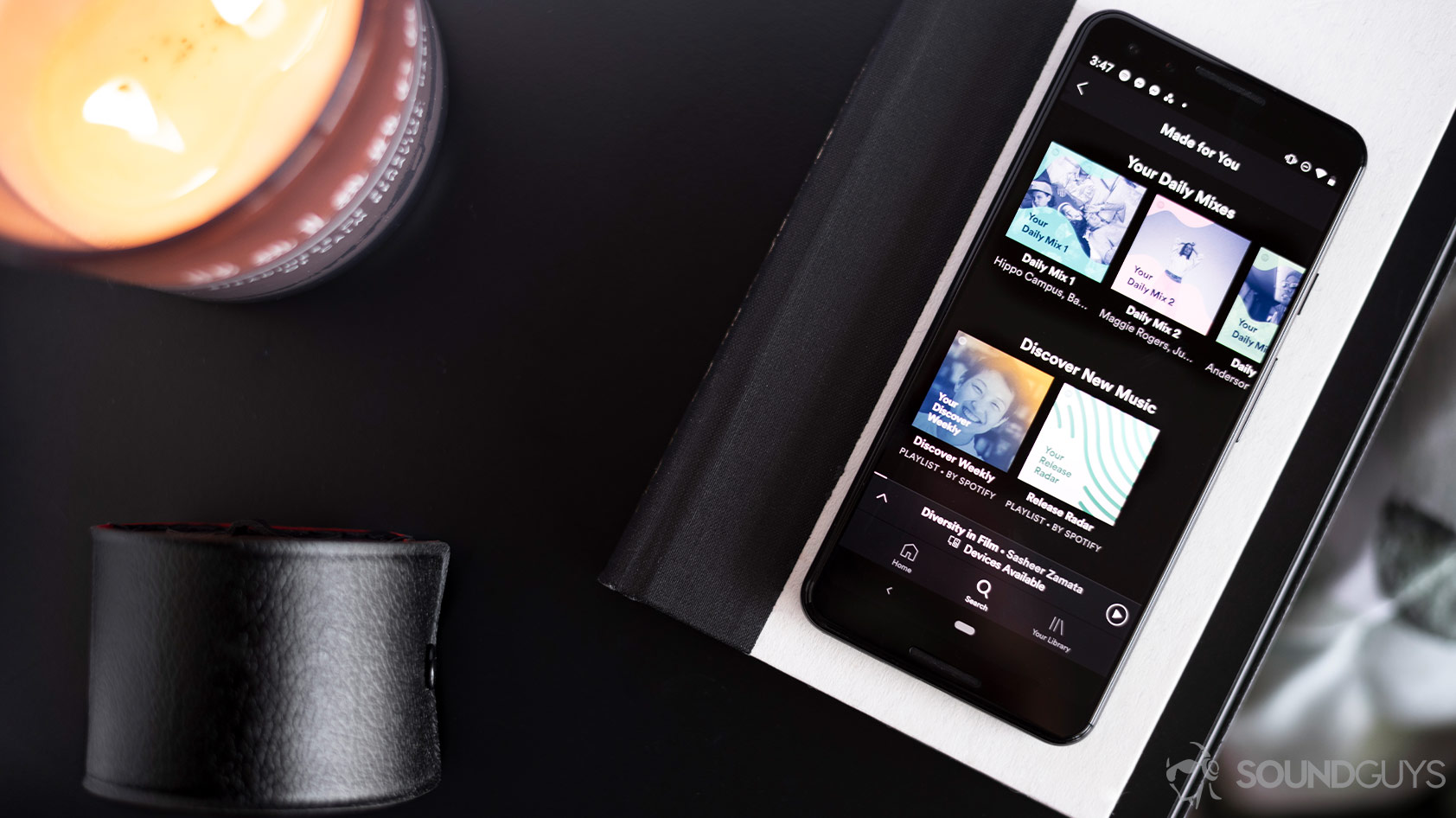 Spotify-3_app Google Pixel 3 aerial A picture of the Spotify app personalized section open on a Google Pixel 3, which is laying flat on a table and book.