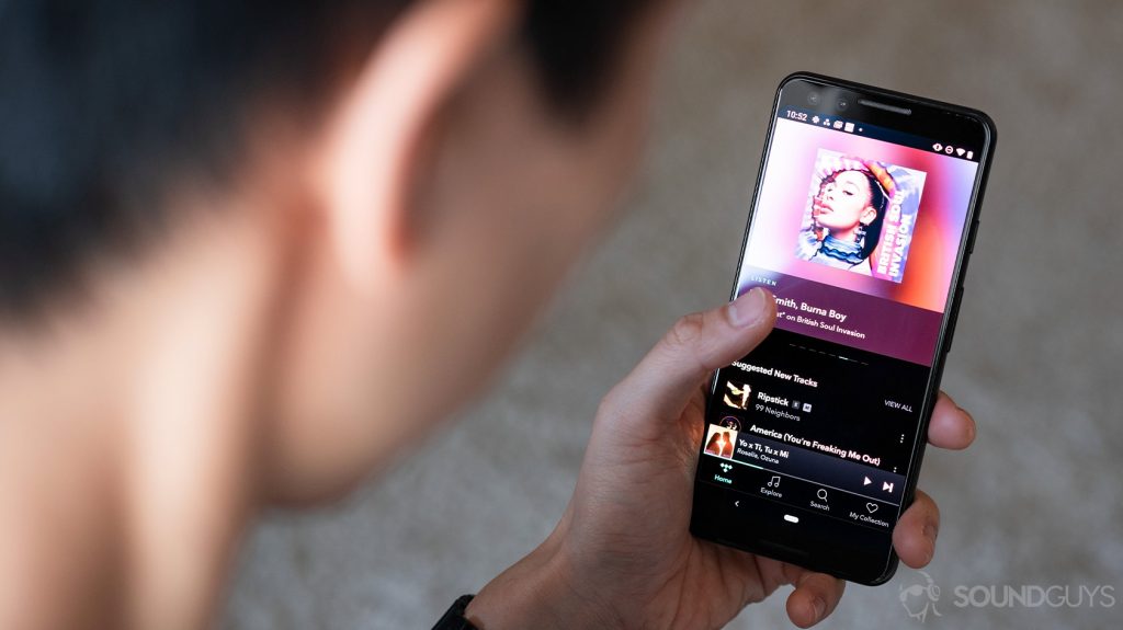 A picture of a woman holding a Google Pixel 3 with the Tidal HiFi app pulled up.