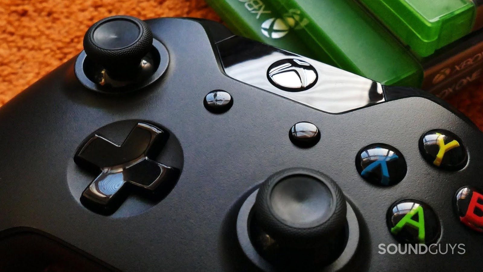 The Microsoft Xbox controller resting near a stack of games.