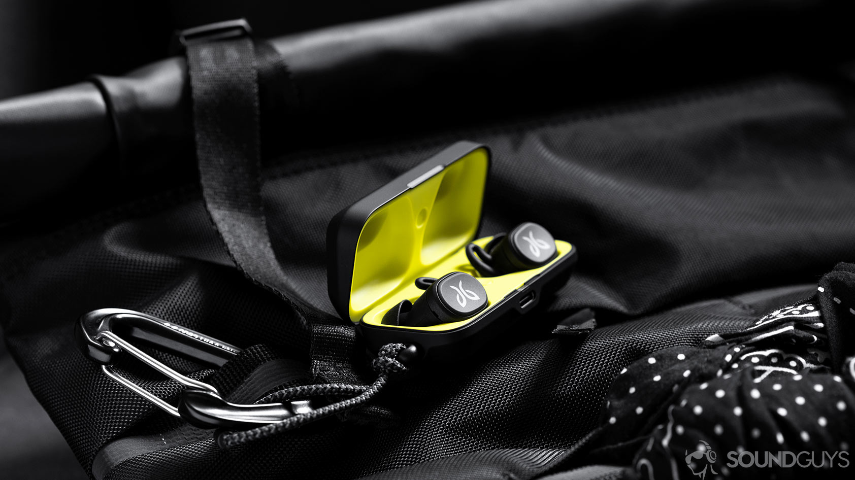 An image of the Jaybird Vista earbuds in charging case which is open and on a Chrome backpack.