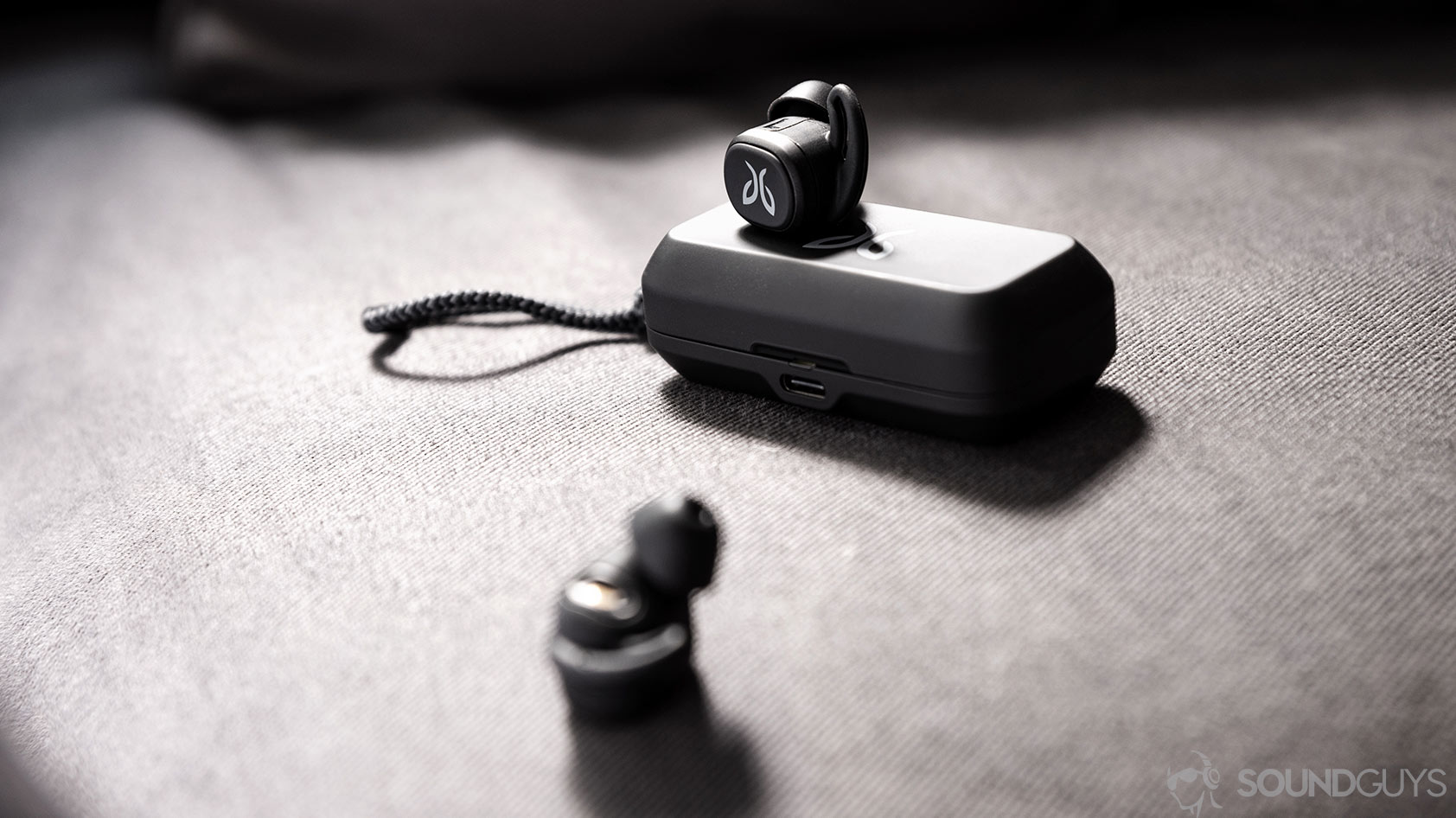 A photo of the Jaybird Vista earbuds outside of the case with one resting on top and the other in the foreground.