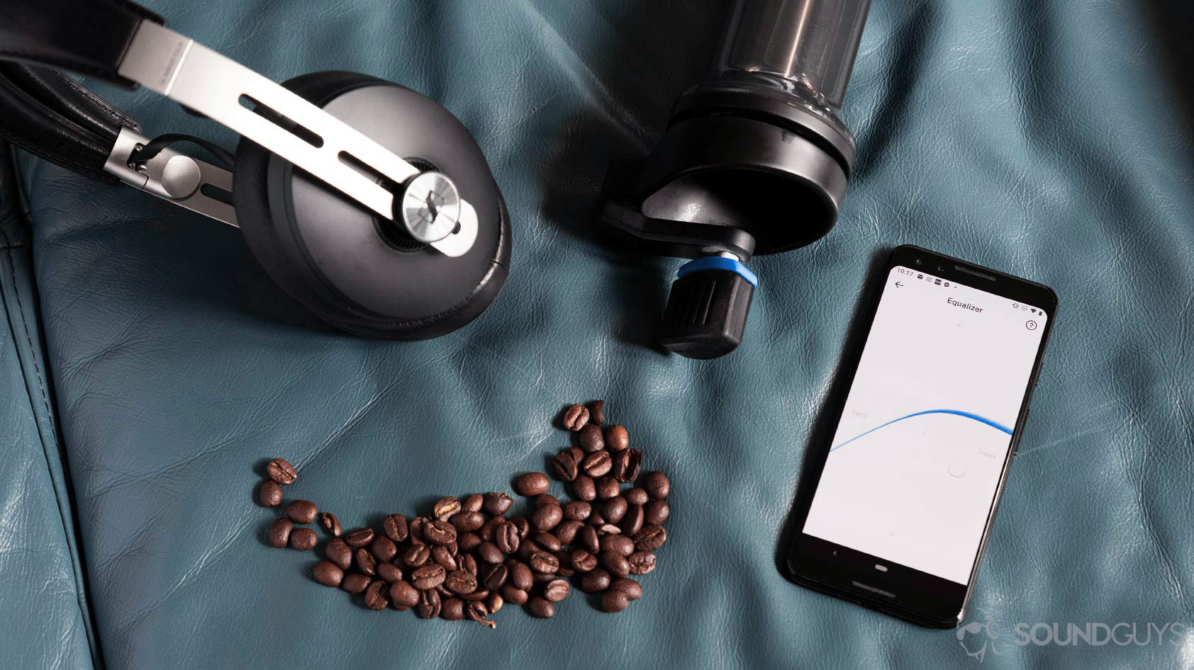 Angled aerial photo of the Sennheiser Momentum Wireless 3 headphones next to Google Pixel 3 with the Smart Control app EQ open next to a coffee grinder and beans.