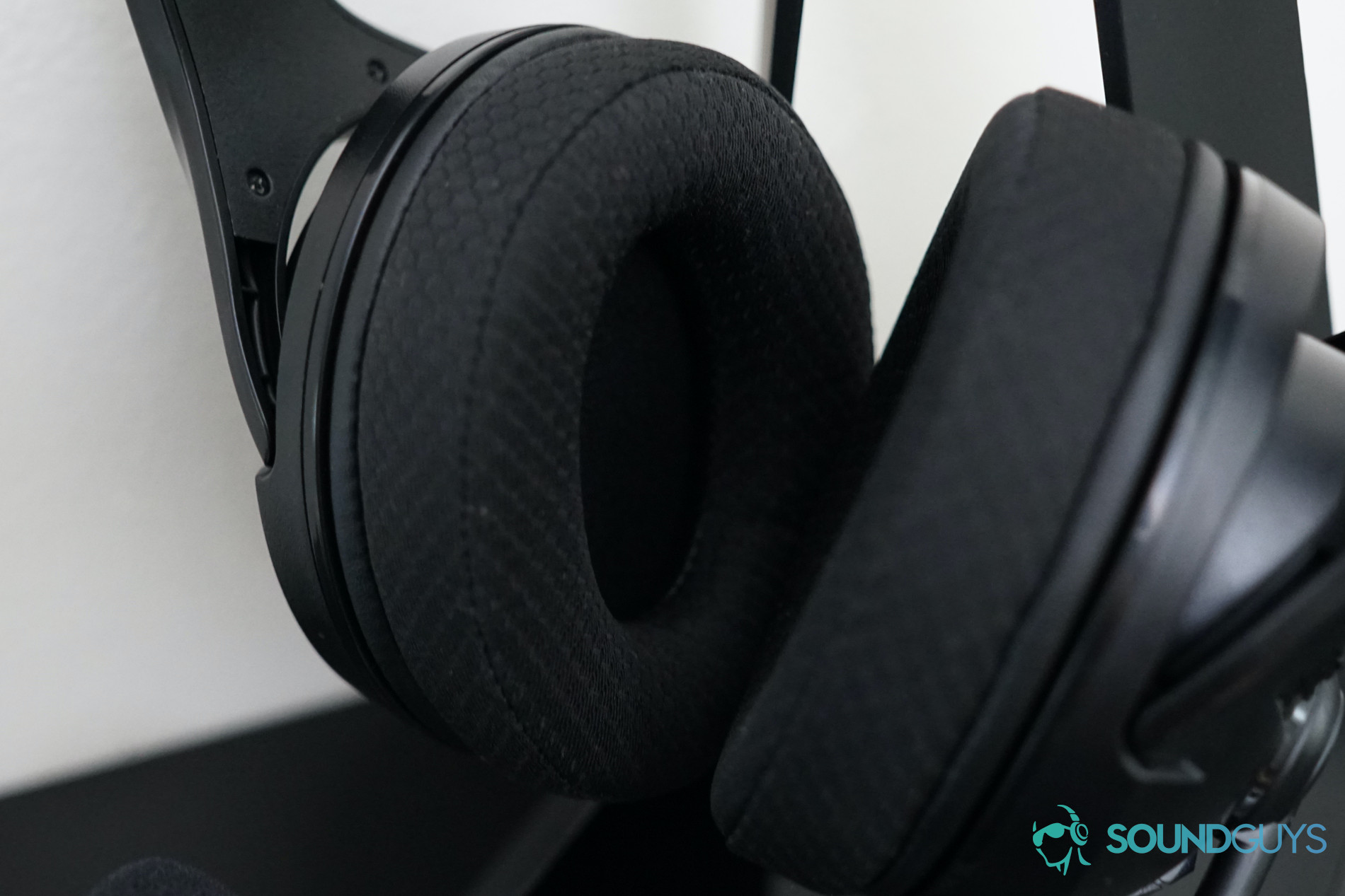 A close-up photo of the fabric earpads of the AmazonBasics Gaming Headset on a stand.