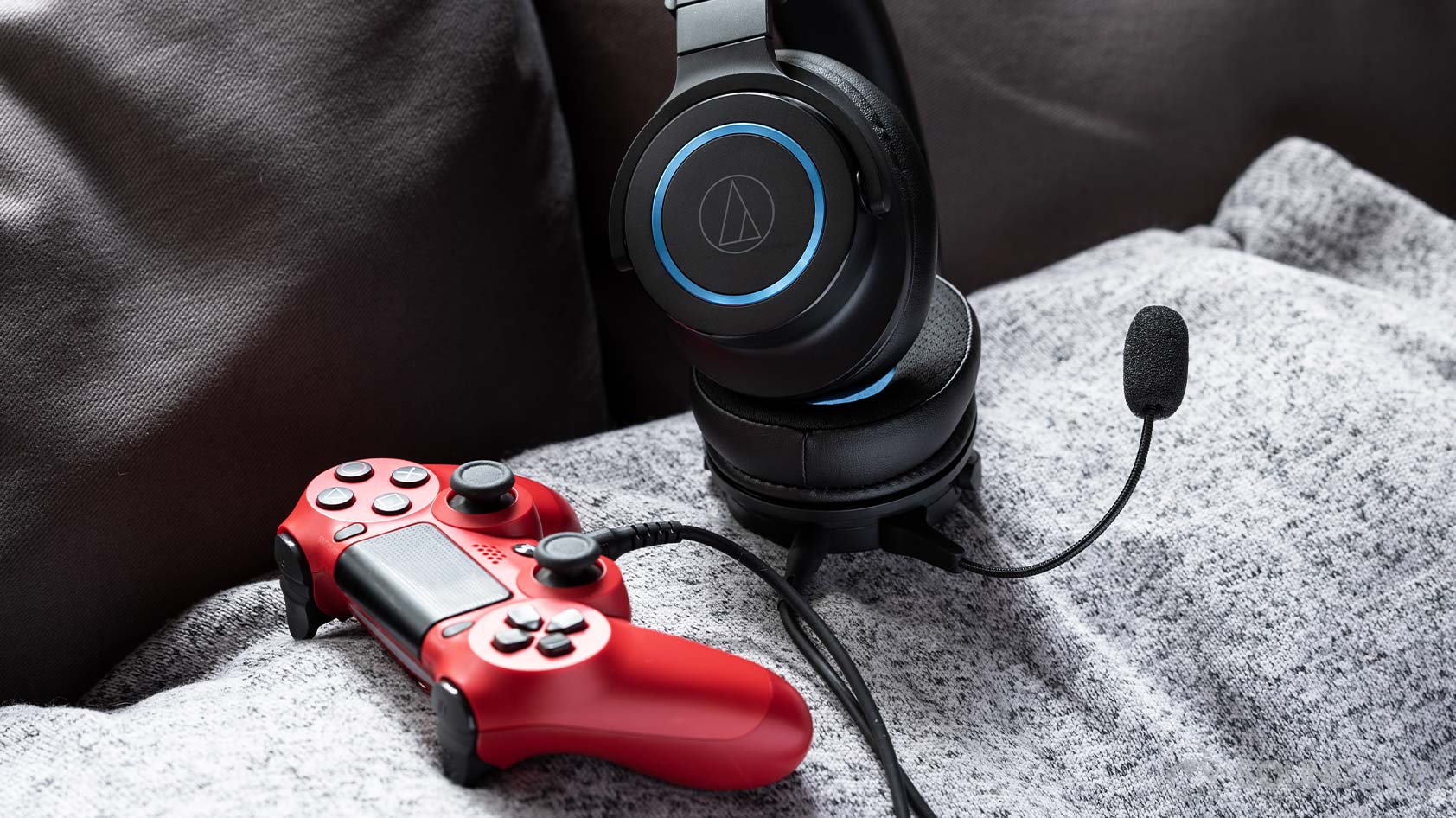 The Audio-Technica ATH-G1 gaming headset plugged into a red PS4 controller.
