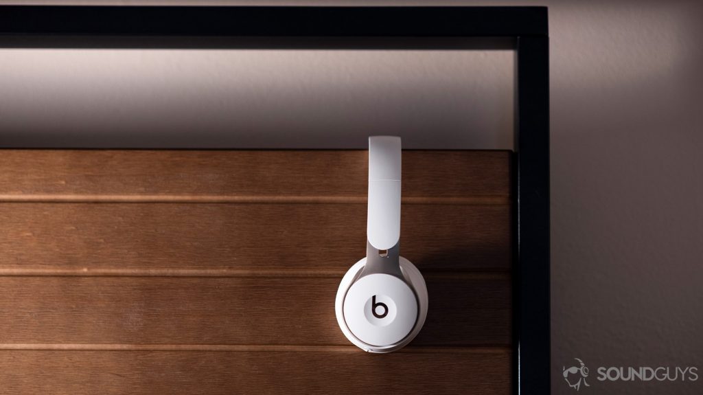 The Beats Solo Pro on-ear noise cancelling headphones in profile against a wooden background.