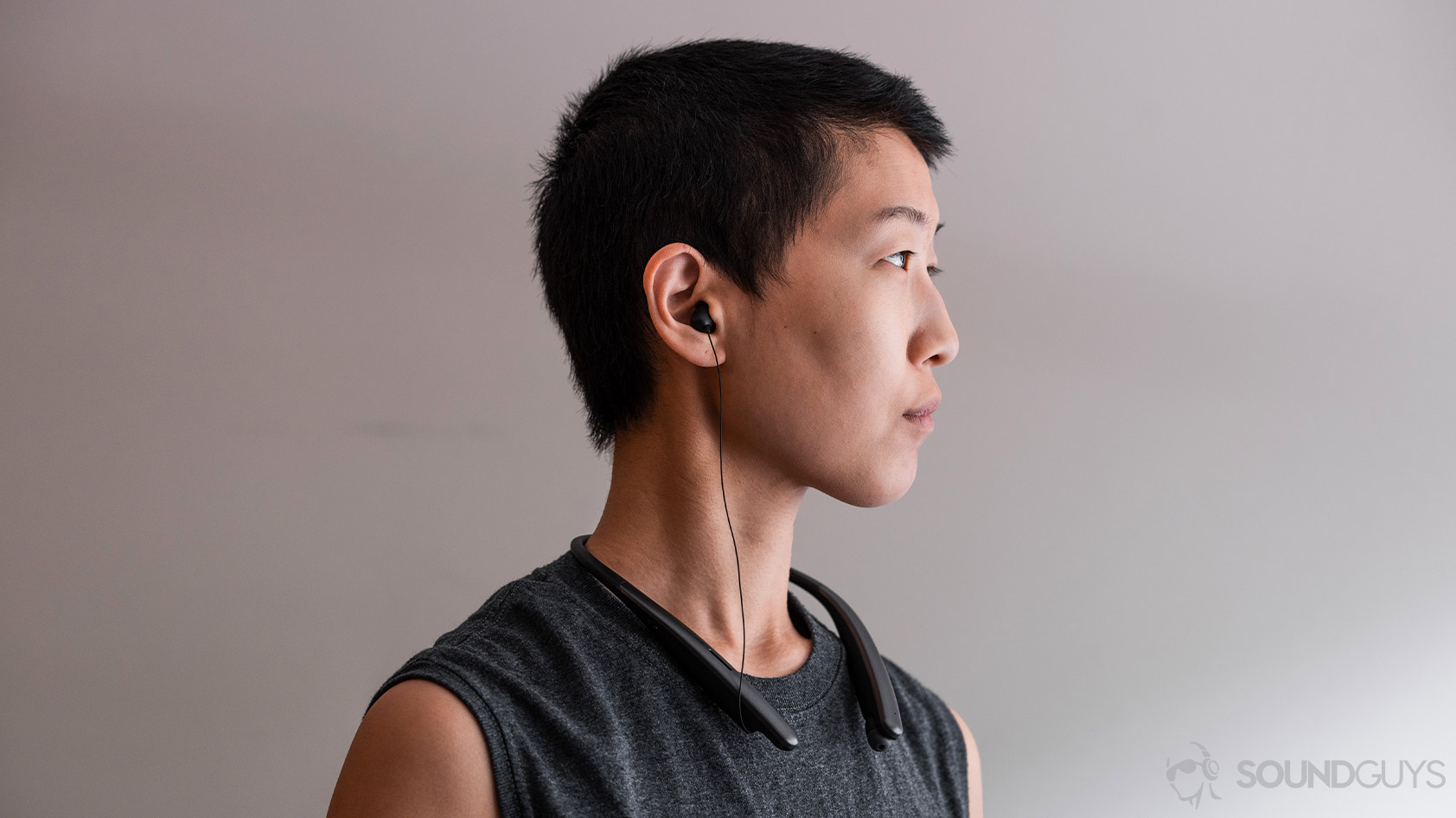 A woman wearing the LG Tone Style SL6s wireless neckband earbuds in profile view.