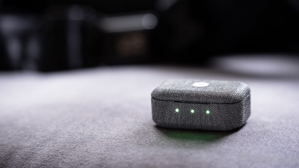 An image of the Master & Dynamic MW07 Go charging case closed with all three LED indicators glowing green.