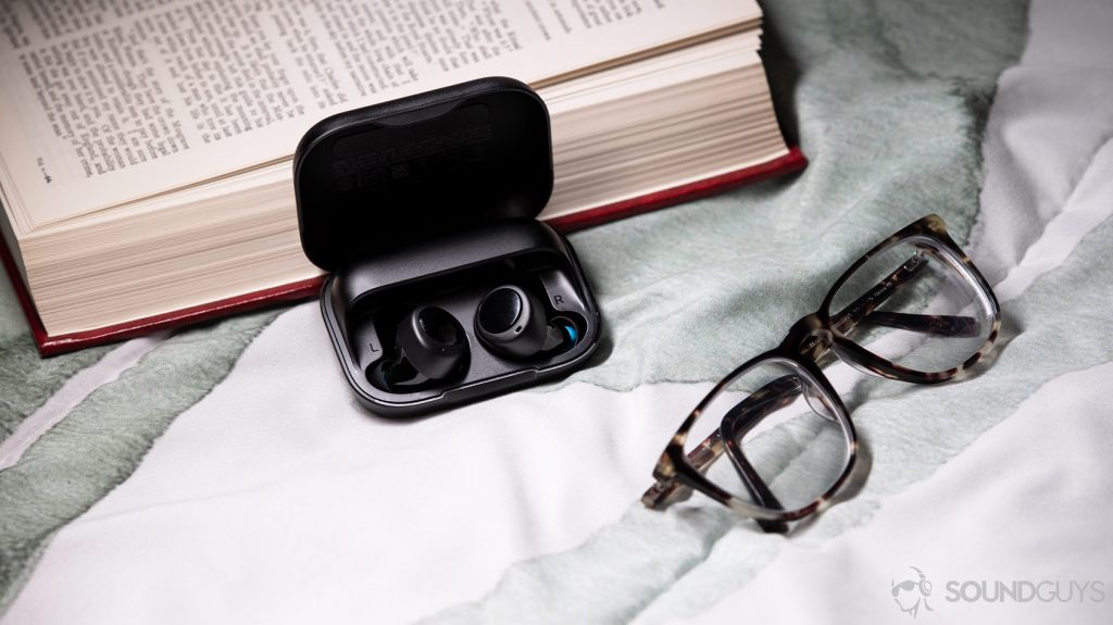 A picture of the Amazon Echo Buds, a runner up as an Apple AirPods Pro alternative, in the case next to glasses and a book.