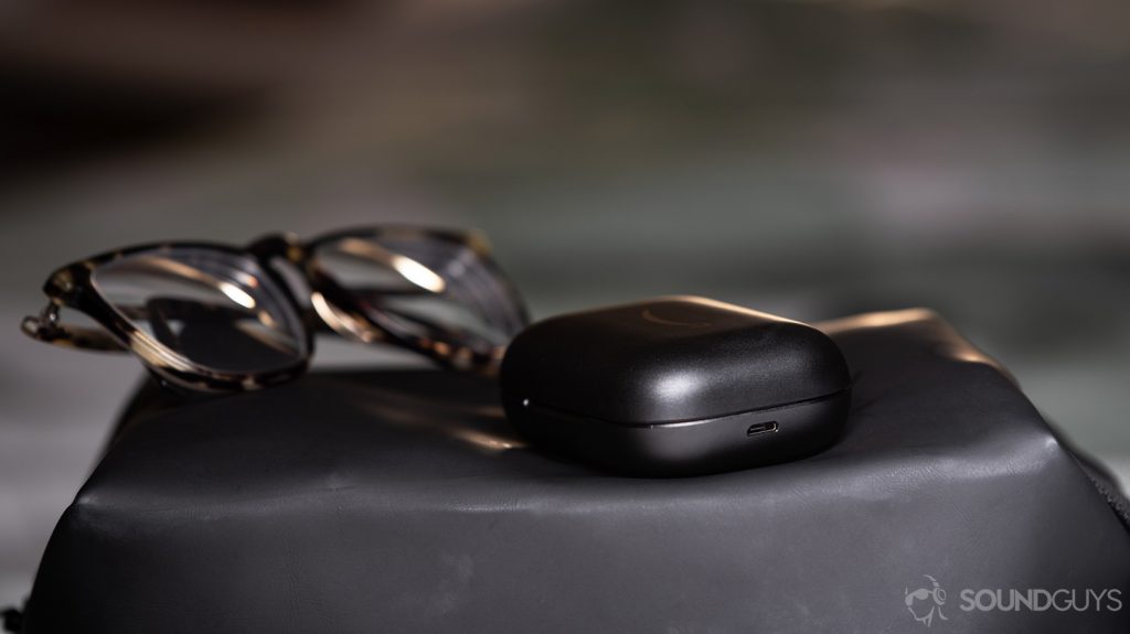 A picture of the Amazon Echo Buds microUSB charging case next to Warby Parker glasses.