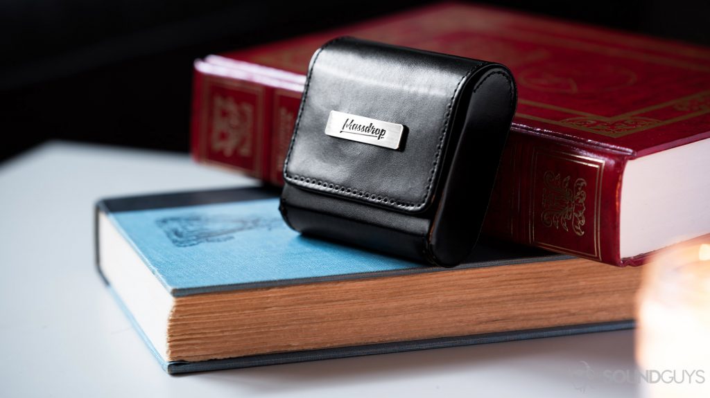 A photo of the Massdrop x MEE audio Pinnacle PX leather carrying case on blue and red books.