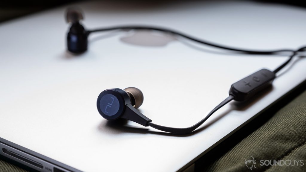 A photo of the Massdrop x NuForce Stride wireless earbuds (blue) atop an Apple Macbook Pro.