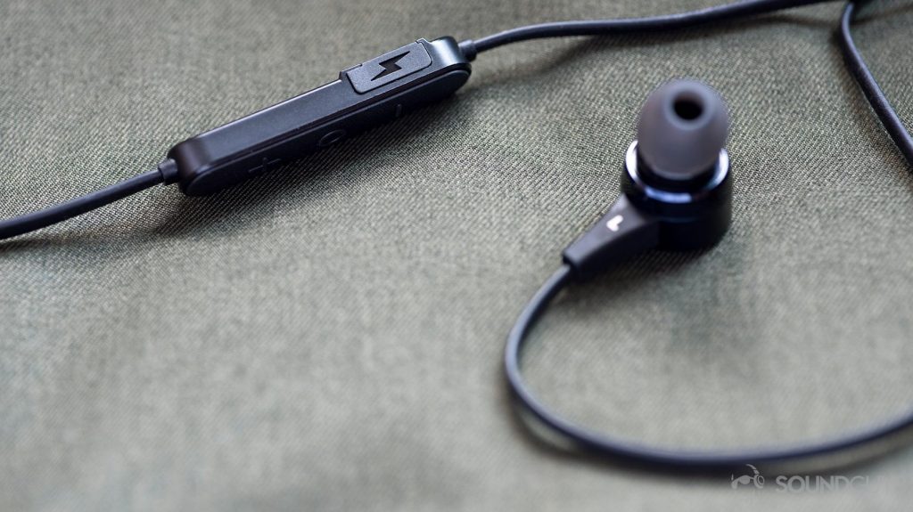 A photo of the Massdrop x NuForce Stride wireless earbuds (blue) and the control module with a plastic cover protecting the microUSB input.