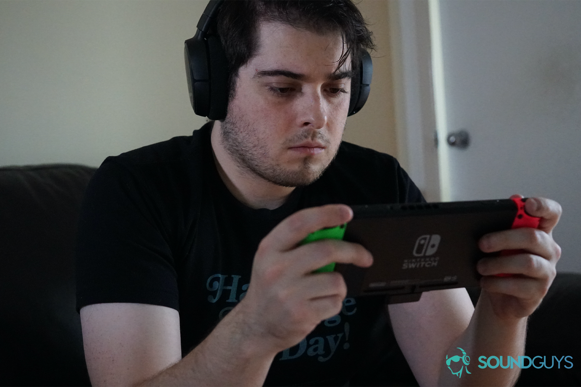 SteelSeries Arctis 1 Wireless Switch Gameplay A man sits on a couch playing a Nintendo Switch with the SteelSeries Arctis 1 Wireless gaming headset.