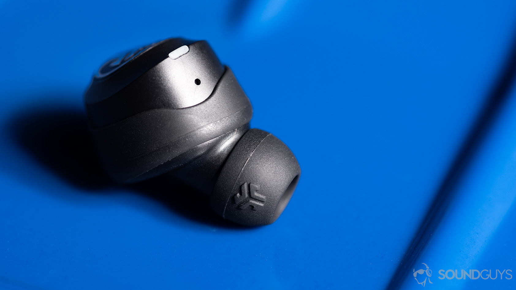 A macro picture of the JLab JBuds Air Icon true wireless earbuds' microphone hole and silicone wing tip.