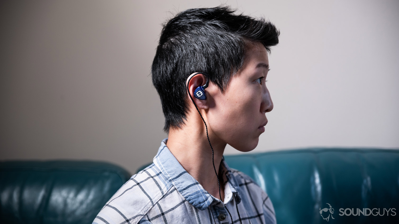 A photo of the Massdrop x Empire Ears Zeus earbuds being worn by a woman looking to the right of the frame.