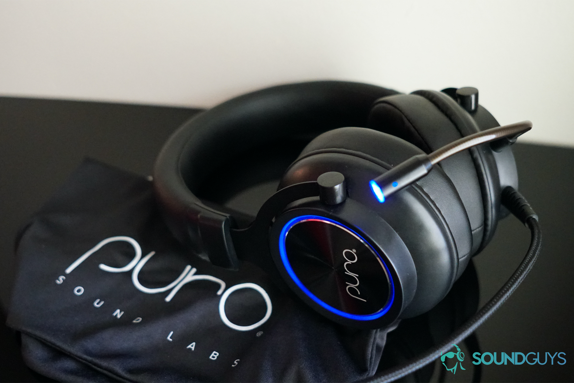 The Puro Sound Labs PuroGamer headset sits on top of its carry bag on a black surface, shown to address the question can headphones cause tinnitus.