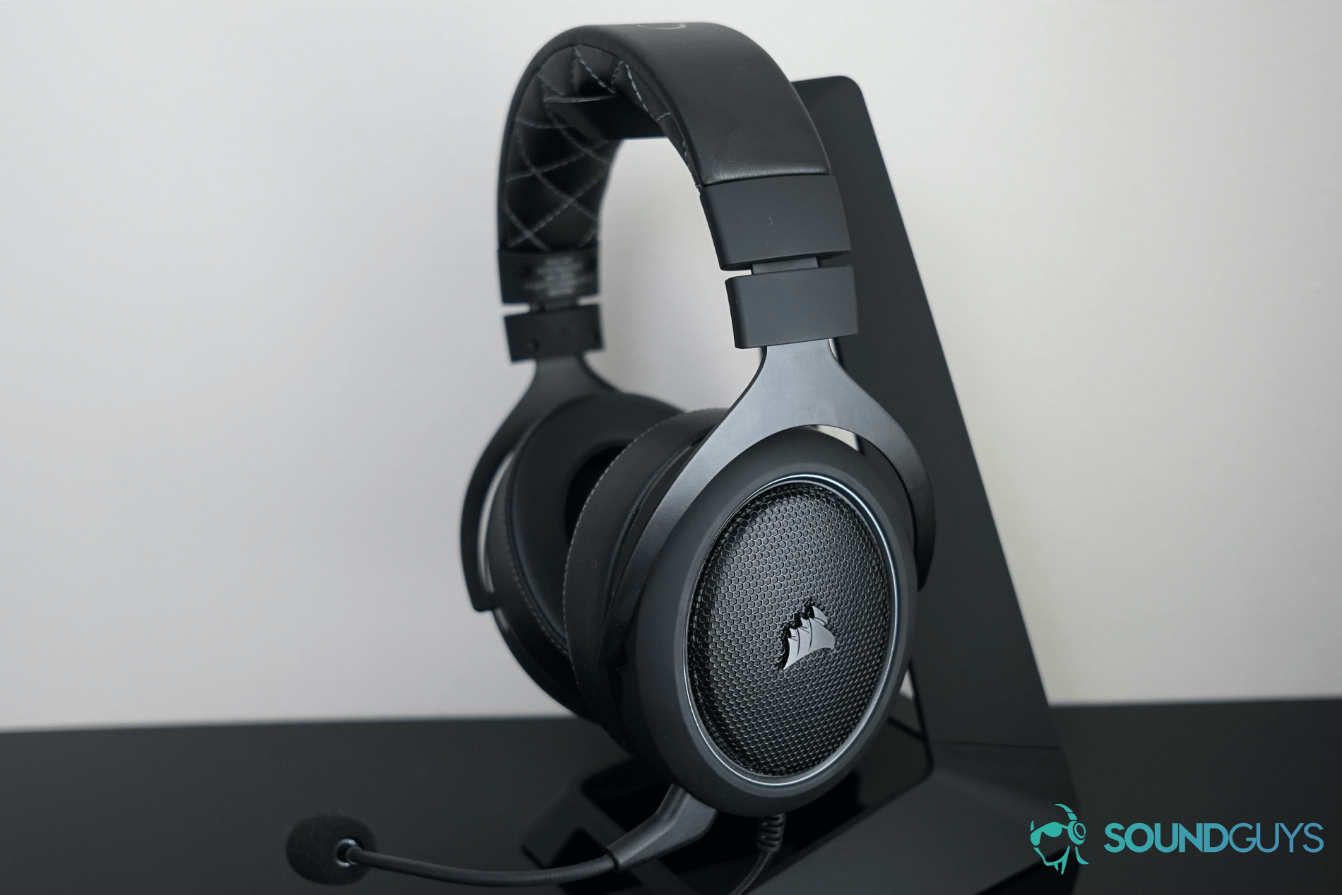 The Corsair HS60 Pro Surround gaming headset on a black headphone stand.