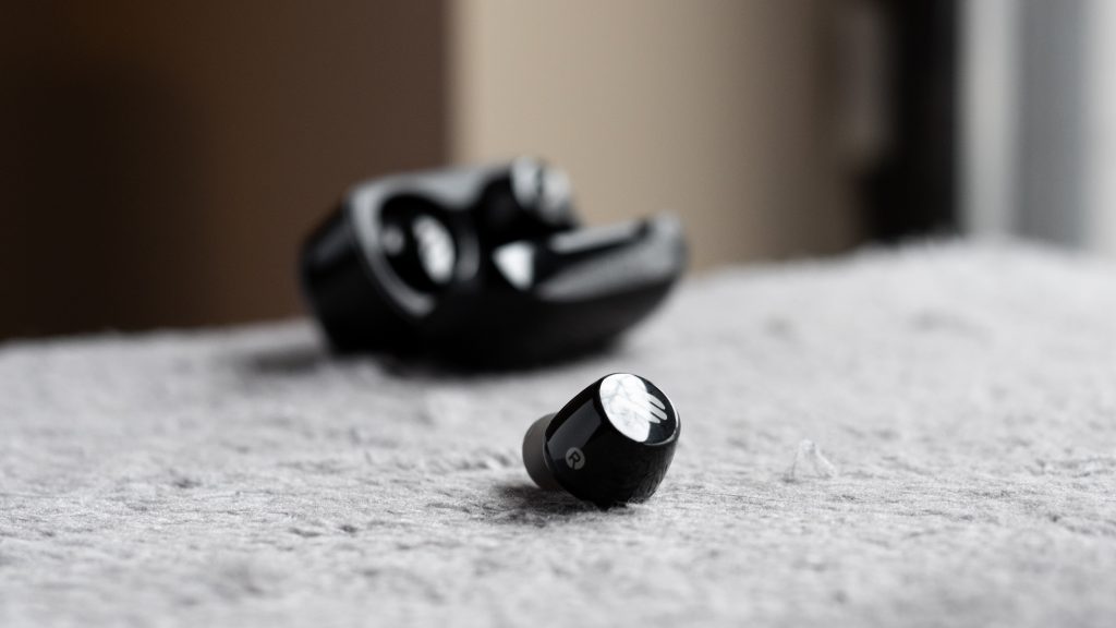 A photo of the Edifier TWS1 true wireless earbuds, one out of the case and the other inside.