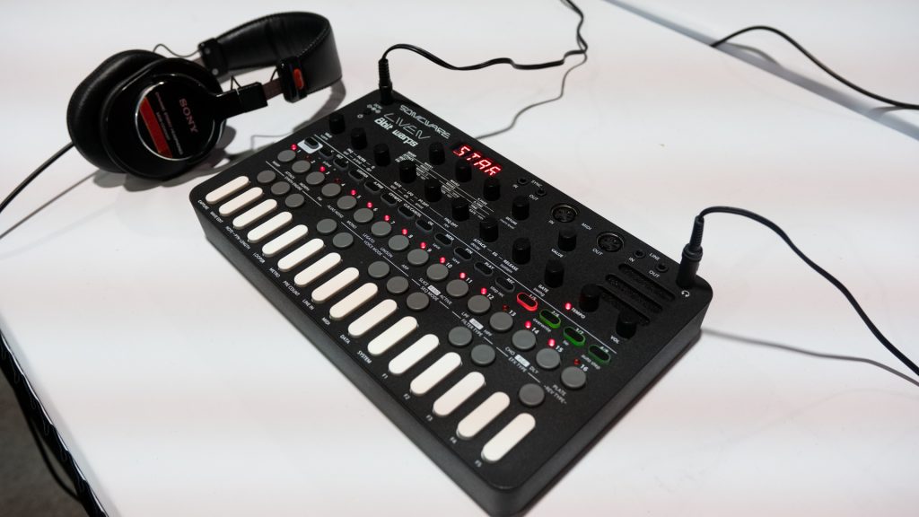 Pictured is the Sonicware Liven 8bit warp synth with a pair of Sony headphones on a white table at NAMM 2020.