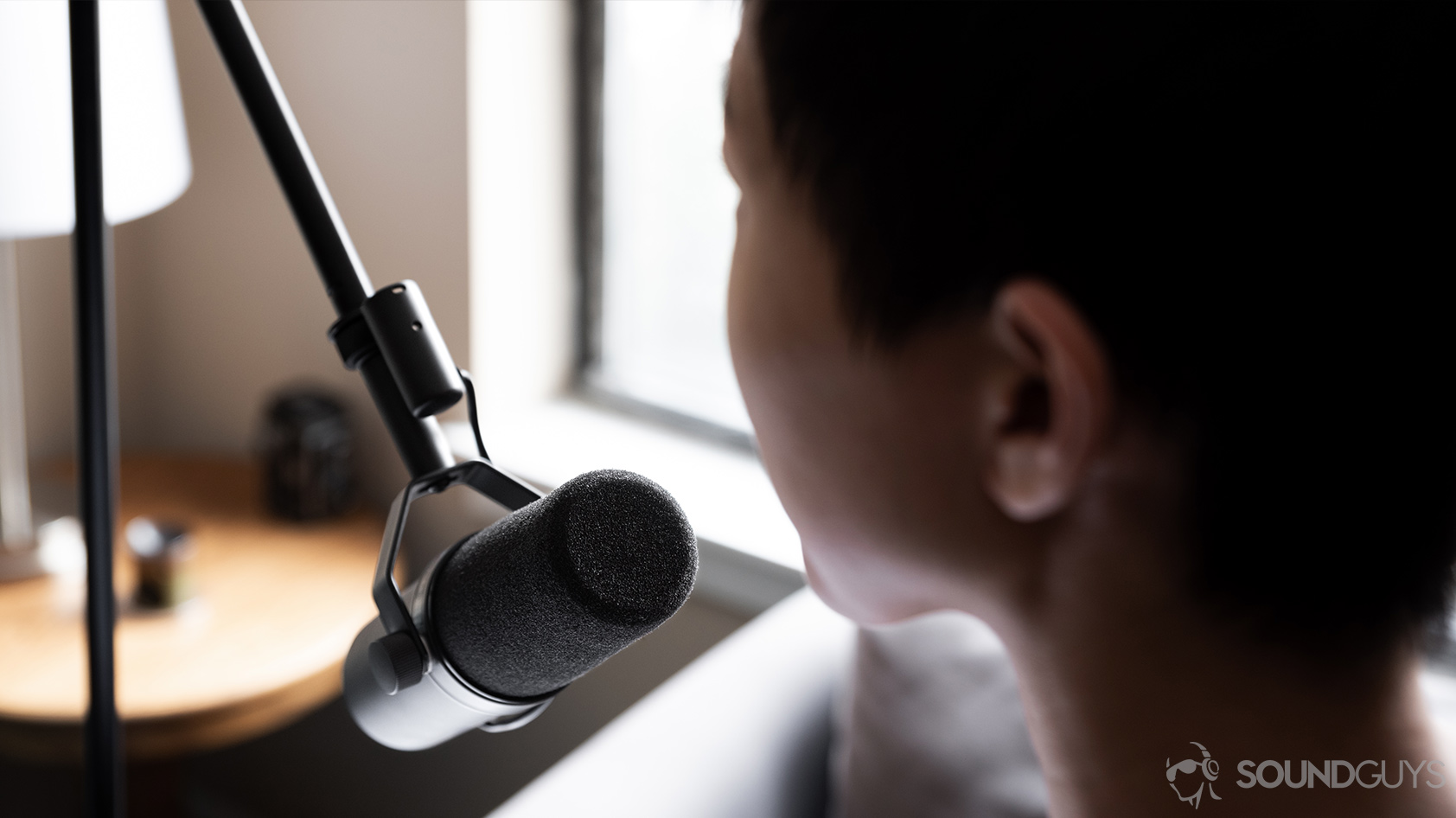 The Shure SM7B dynamic microphone facing a woman speaking into it.