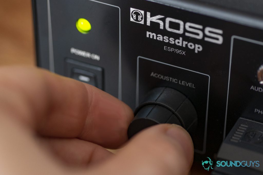 A photo of the Massdrop x Koss ESP/95X's E/90x Electrostatic Energizer in use, showcasing the split volume knob.