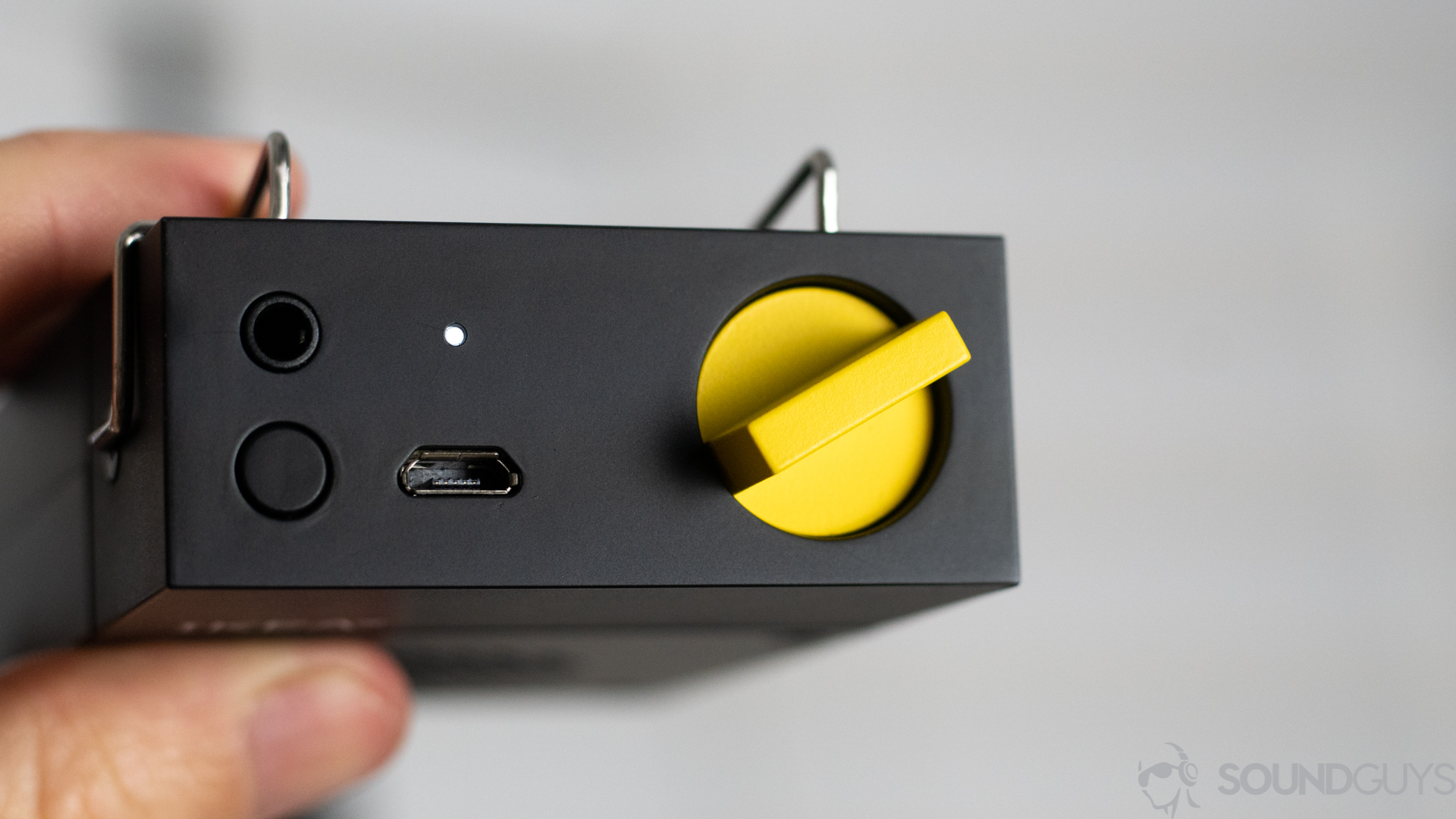 Pictured is the bright yellow volume volume button, 3.5mm input, and microUSB input of the Frekvens Portable speaker.