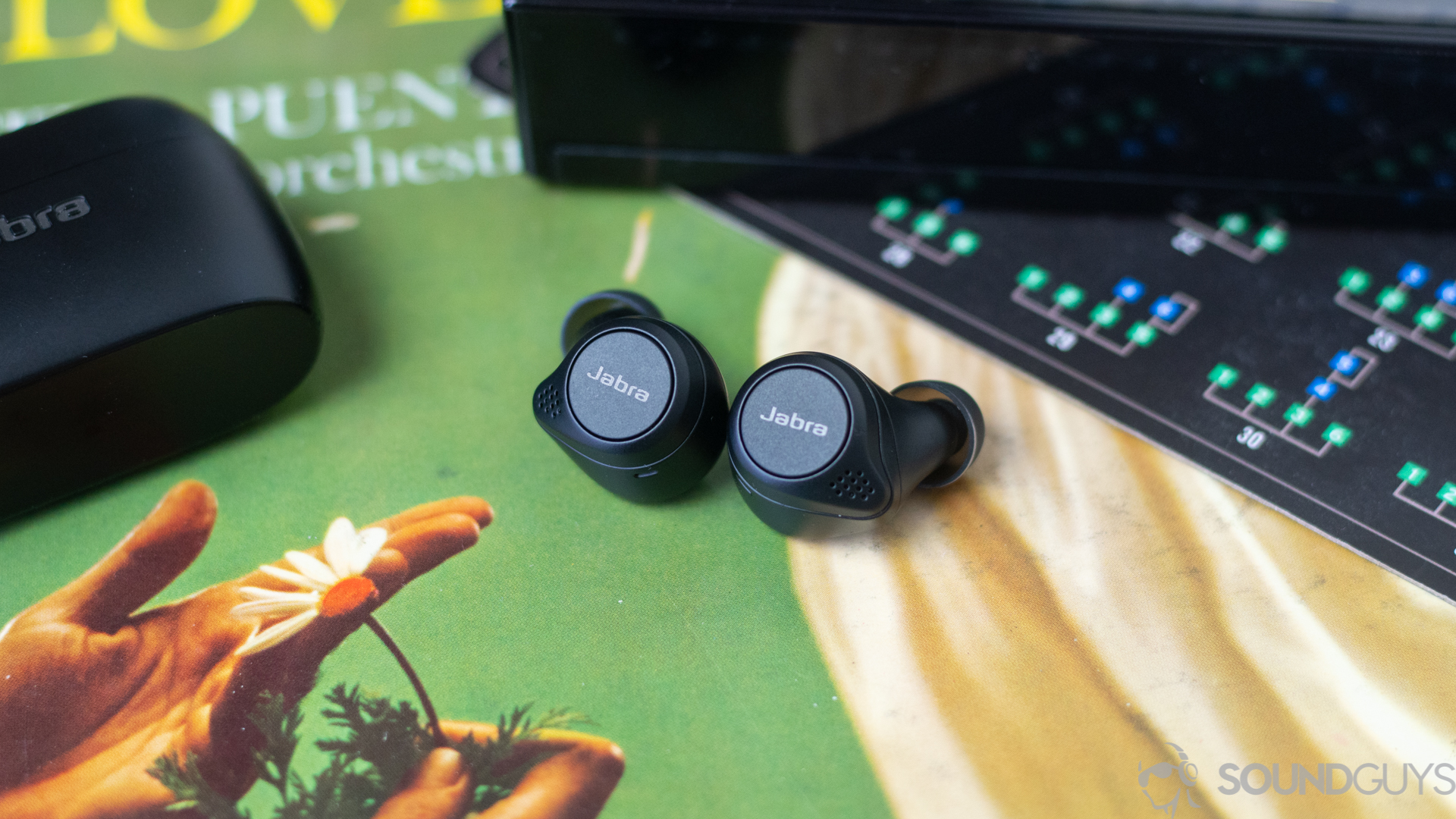 Close-up of the Jabra Elite 75t earbuds playback buttons on an old record