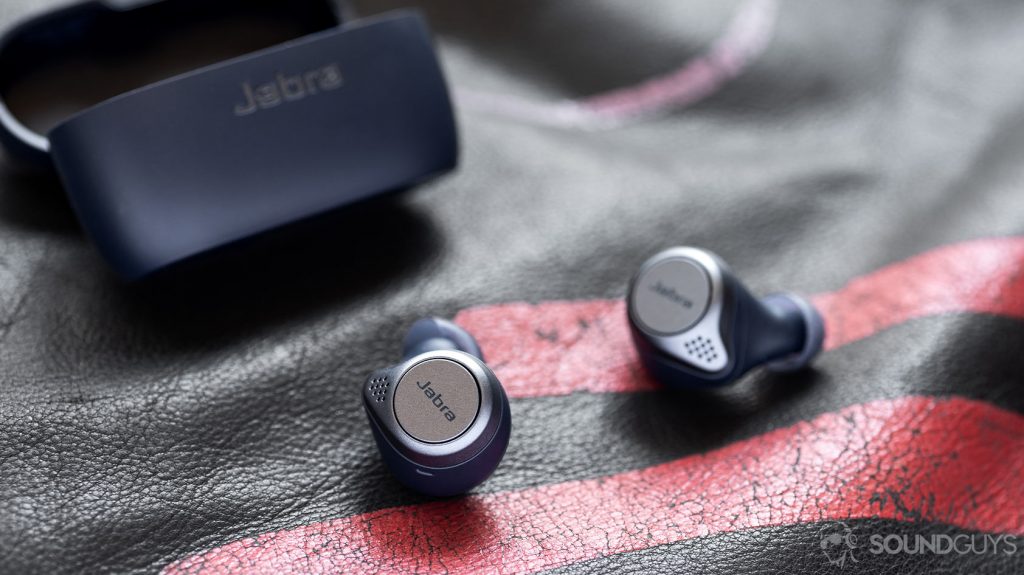 A picture of the Jabra Elite Active 75t true wireless workout earbuds (navy) on a leather surface with the charging case open in the background.